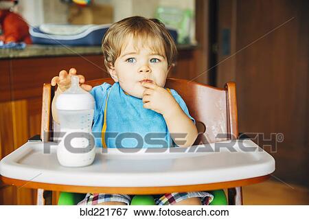 Mixed race baby boy drinking bottle in high chair View Large Photo Image Stock Photo - Mixed race baby boy drinking bottle in high chair. Fotosearch