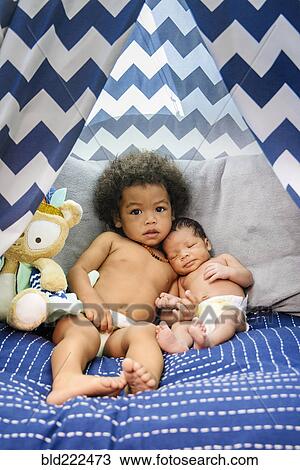 Mixed Race baby boys cuddling on bed View Large Photo Image Stock Image - Mixed Race baby boys cuddling on bed. Fotosearch