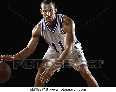 Stock Photograph - Mixed race basketball player bouncing basketball. Fotosearch