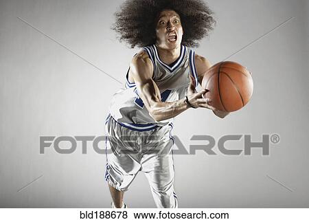 Stock Photo - Mixed race basketball player holding basketball. Fotosearch