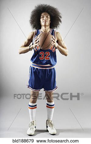 Stock Photo - Mixed race basketball player holding basketball. Fotosearch
