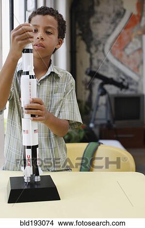 Picture - Mixed race boy building model rocket. Fotosearch