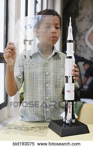 Mixed race boy building model rocket View Large Photo Image Stock Photography - Mixed race boy building model rocket. Fotosearch
