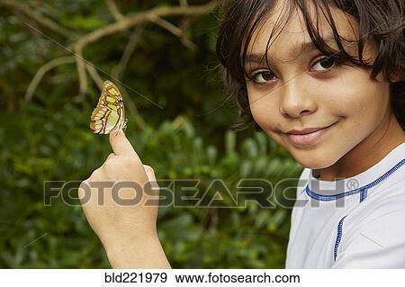 Stock Photo - Mixed race boy holding butterfly. Fotosearch