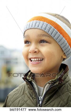 Stock Photo - Mixed race boy in cap outdoors. Fotosearch