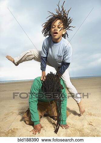 Mixed Race boy jumping over father on beach View Large Photo Image Stock Image - Mixed Race boy jumping over father on beach. Fotosearch