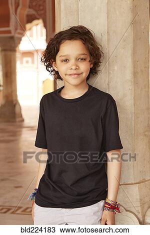 Stock Image - Mixed Race boy leaning on pillar. Fotosearch