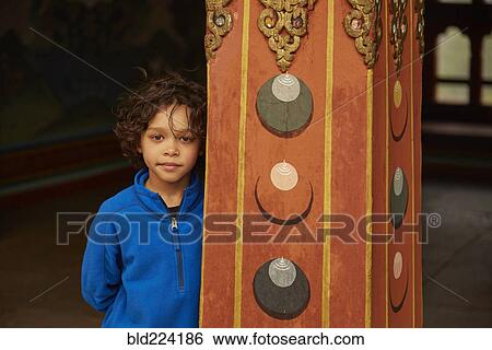 Stock Photograph - Mixed Race boy leaning on pillar. Fotosearch