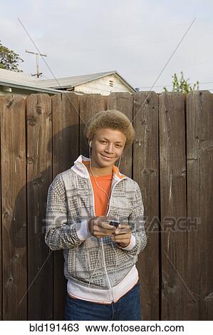 Stock Image - Mixed race boy listening to mp3 player. Fotosearch