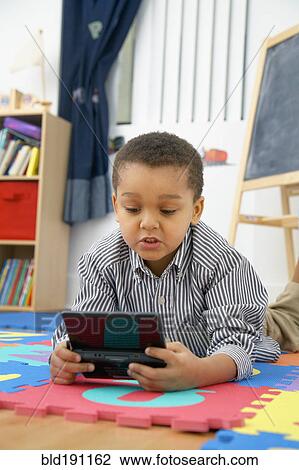 Stock Image - Mixed race boy playing video game. Fotosearch