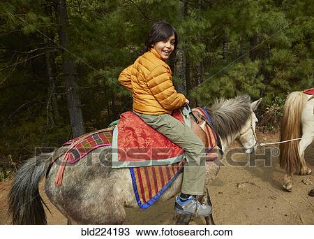 Mixed Race boy riding horse View Large Photo Image Stock Image - Mixed Race boy riding horse. Fotosearch