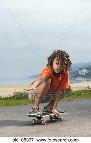 Stock Photo - Mixed Race boy riding skateboard. Fotosearch