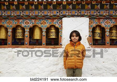 Mixed Race boy standing near prayer wheels View Large Photo Image Stock Image - Mixed Race boy standing near prayer wheels. Fotosearch
