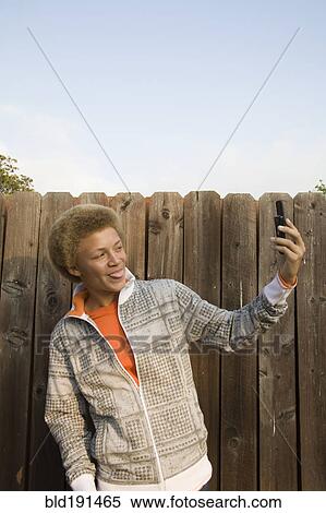 Mixed race boy taking self-portrait with cell phone View Large Photo Image Stock Photography - Mixed race boy taking self-portrait with cell phone. Fotosearch