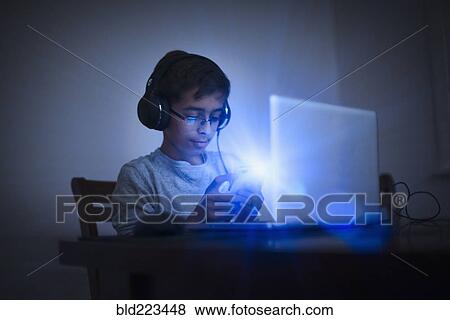 Mixed Race boy using cell phone and laptop View Large Photo Image Stock Photo - Mixed Race boy using cell phone and laptop. Fotosearch
