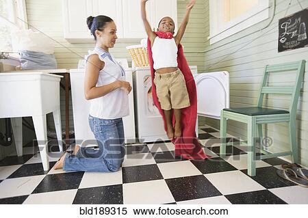 Mixed race boy using towel to play superhero View Large Photo Image Stock Photography - Mixed race boy using towel to play superhero. Fotosearch