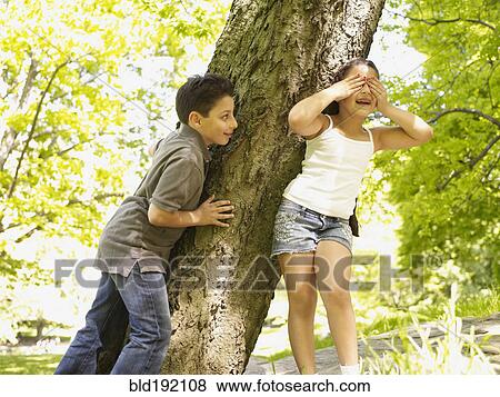 Stock Photo - Mixed race brother and sister playing hide-and-seek. Fotosearch