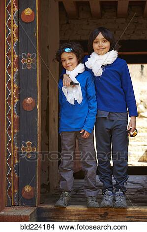 Picture - Mixed Race brothers hugging in doorway. Fotosearch