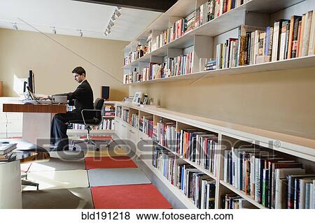 Stock Photo - Mixed race businessman sitting at desk. Fotosearch