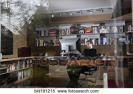Stock Photography - Mixed race businessman sitting at desk. Fotosearch