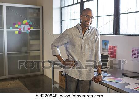 Mixed race businessman smiling in office View Large Photo Image Stock Photo - Mixed race businessman smiling in office. Fotosearch