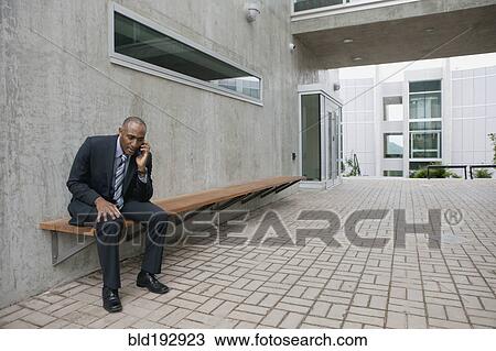 Mixed race businessman talking on cell phone in courtyard View Large Photo Image Stock Image - Mixed race businessman talking on cell phone in courtyard. Fotosearch