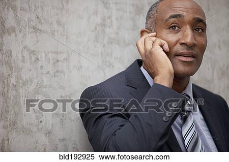 Stock Photography - Mixed race businessman talking on cell phone. Fotosearch