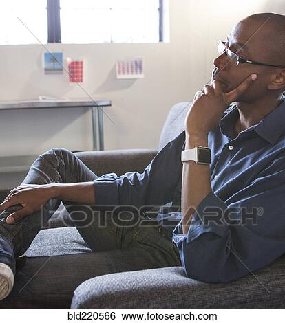 Mixed race businessman thinking in office View Large Photo Image Stock Photograph - Mixed race businessman thinking in office. Fotosearch