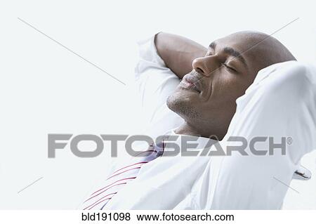 Mixed race businessman with hands behind head and eyes closed View Large Photo Image Stock Photo - Mixed race businessman with hands behind head and eyes closed. Fotosearch