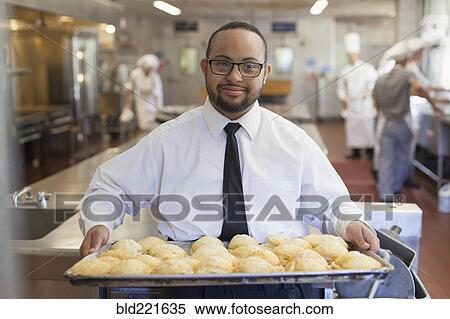 Stock Photography - Mixed race chef with down syndrome cooking in restaurant. Fotosearch