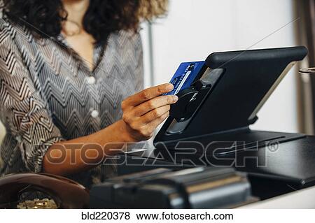 Mixed race clerk swiping credit card at register View Large Photo Image Stock Photo - Mixed race clerk swiping credit card at register. Fotosearch
