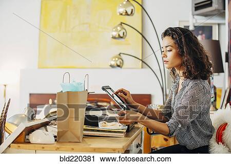 Mixed race clerk using register in shop View Large Photo Image Stock Image - Mixed race clerk using register in shop. Fotosearch