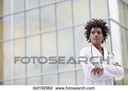 Mixed race doctor standing outdoors with arms crossed View Large Photo Image Stock Image - Mixed race doctor standing outdoors with arms crossed. Fotosearch