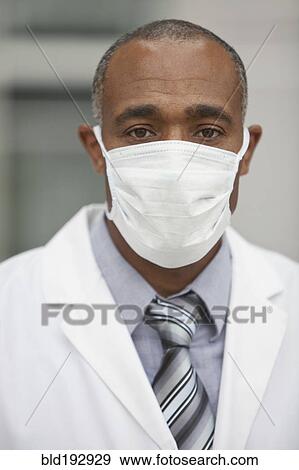 Stock Photo - Mixed race doctor wearing surgical mask. Fotosearch