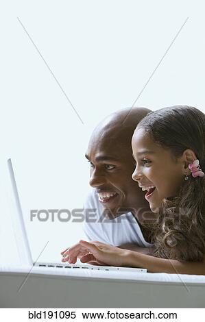 Mixed race father and daughter using laptop View Large Photo Image Stock Photography - Mixed race father and daughter using laptop. Fotosearch