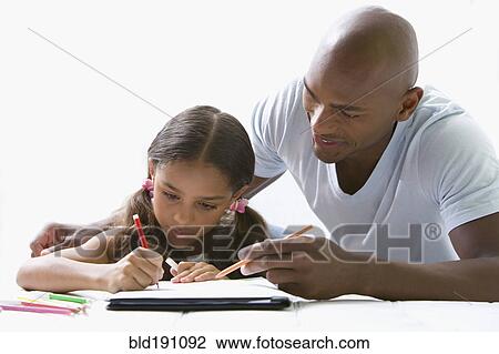 Stock Image - Mixed race father helping daughter with homework. Fotosearch