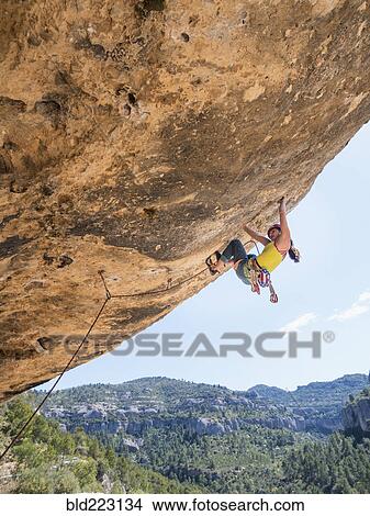 Picture - Mixed Race girl climbing rock. Fotosearch