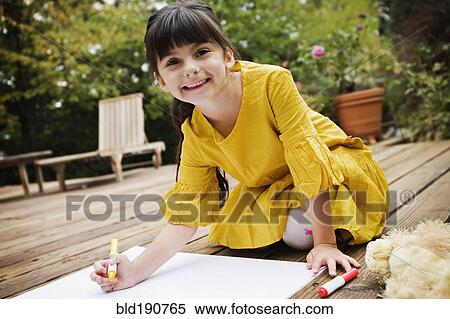 Stock Photography - Mixed race girl coloring on deck. Fotosearch