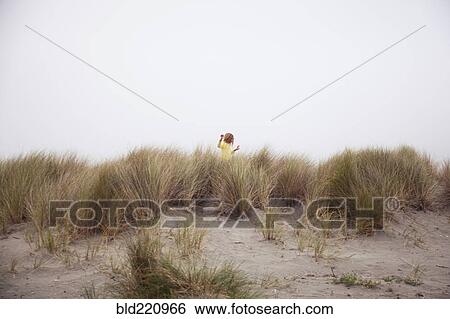 Stock Photograph - Mixed race girl exploring beach. Fotosearch