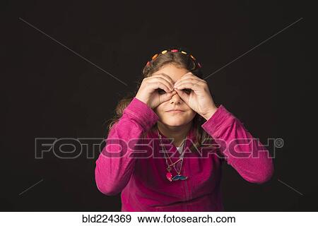 Stock Photo - Mixed Race girl gesturing binoculars. Fotosearch