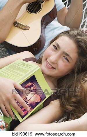 Mixed Race girl holding book View Large Photo Image Stock Photo - Mixed Race girl holding book. Fotosearch