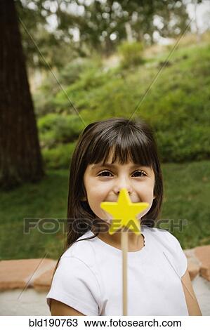 Stock Image - Mixed race girl holding star wand. Fotosearch