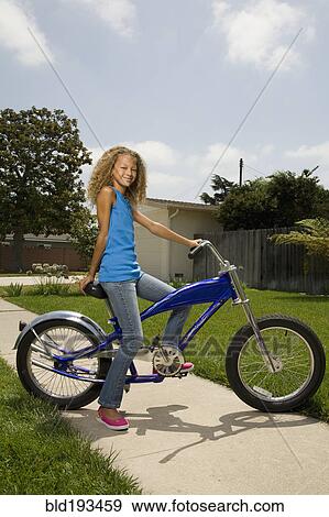 Stock Photo - Mixed race girl on bicycle. Fotosearch