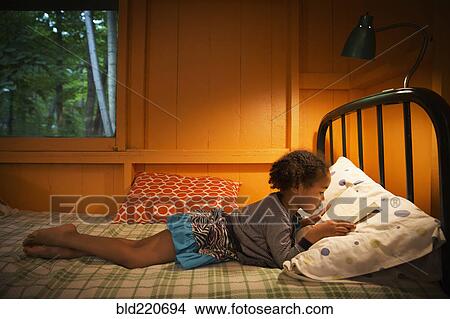 Mixed race girl reading on bed View Large Photo Image Picture - Mixed race girl reading on bed. Fotosearch