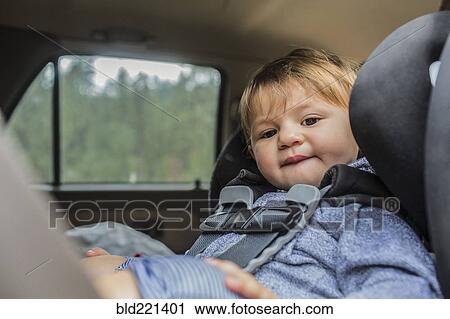 Stock Image - Mixed race girl sitting in car seat. Fotosearch