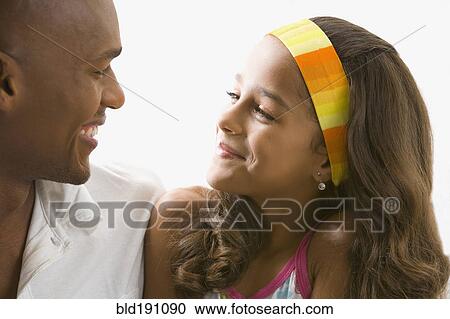 Stock Image - Mixed race girl smiling at father. Fotosearch