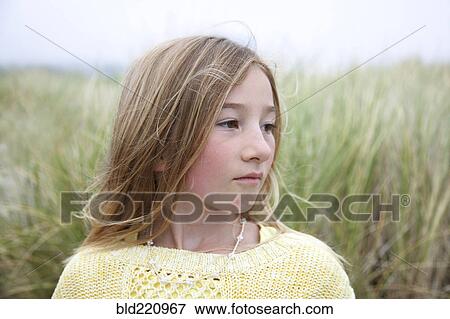 Stock Photo - Mixed race girl standing in grass. Fotosearch