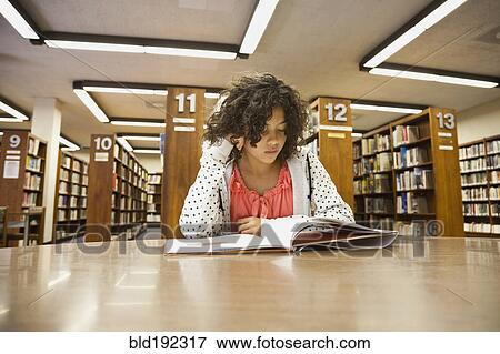 Stock Photo - Mixed race girl studying in library. Fotosearch