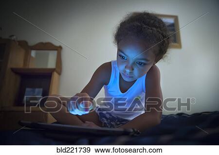 Stock Photo - Mixed race girl using digital tablet. Fotosearch