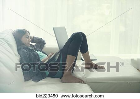 Mixed Race girl using laptop on sofa View Large Photo Image Stock Image - Mixed Race girl using laptop on sofa. Fotosearch